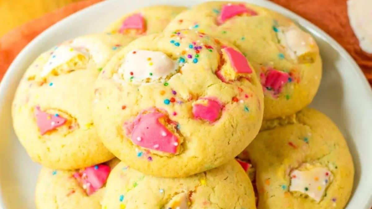 A plate of soft sugar cookies with frosted animal crackers inside.