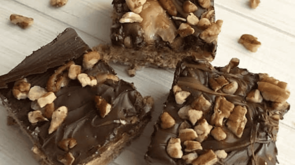 chocolate and caramel rice krispie treats with nuts on top.