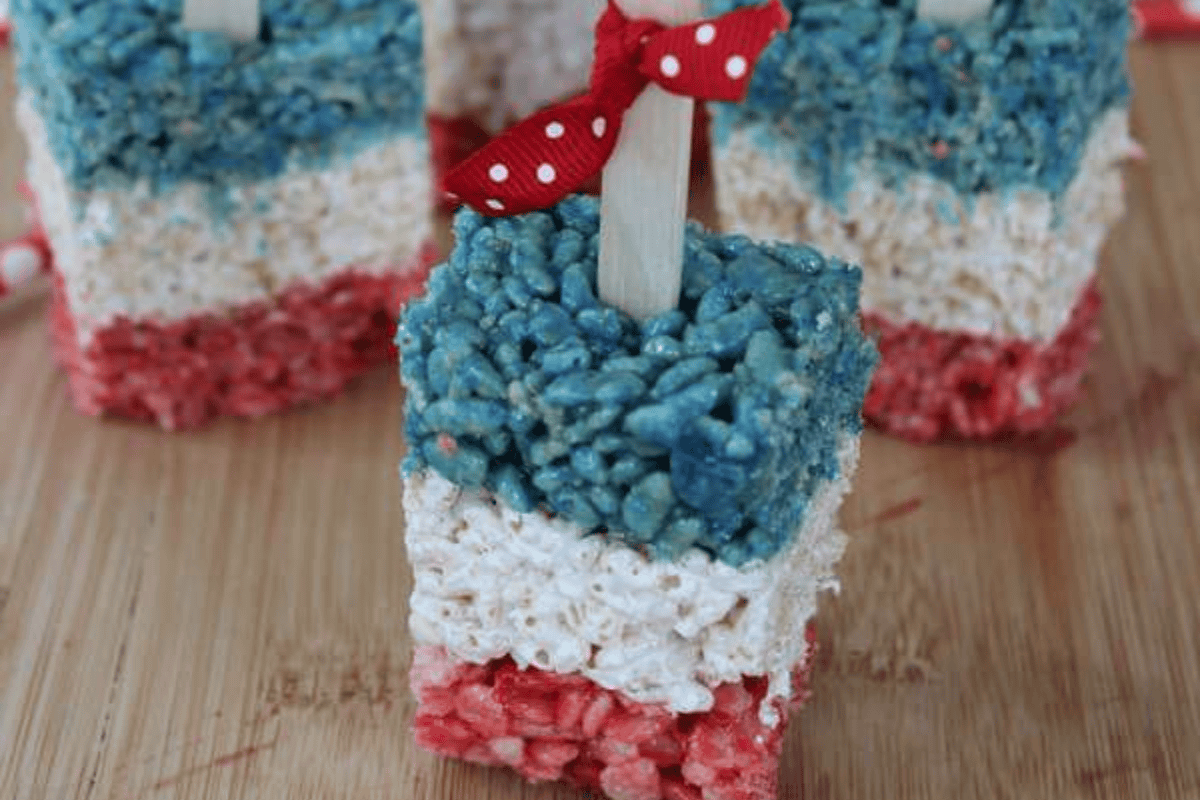 Patriotic Rice Krispies Treats Pops on a wooden board.