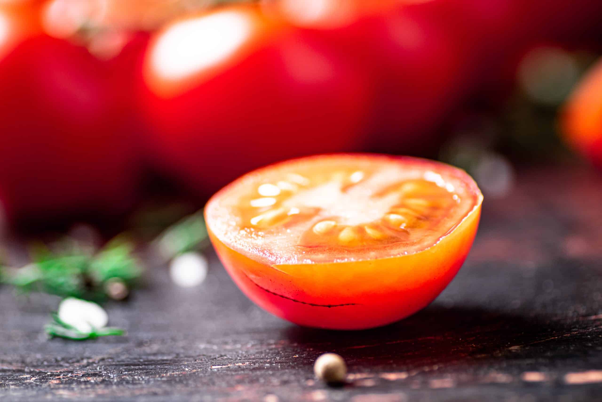 Tomatoes on a branch with pieces of greens and spices. Against a dark background. High quality photo