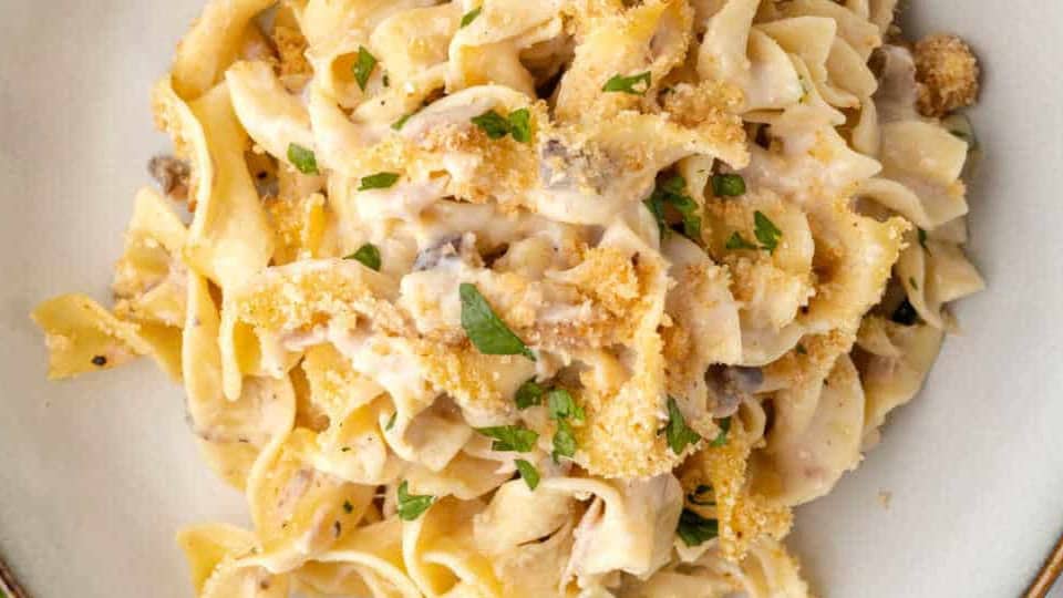 Tuna noodle casserole in a cream dish.