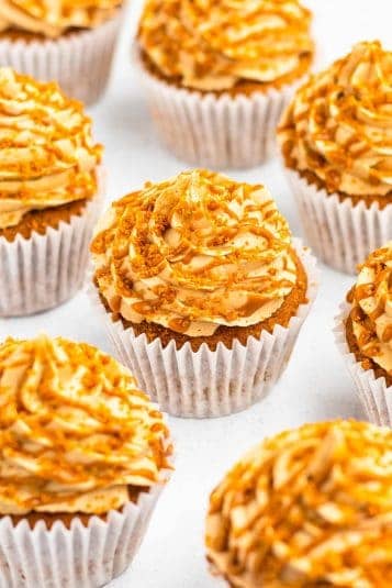 Biscoff cupcakes on a white table top.