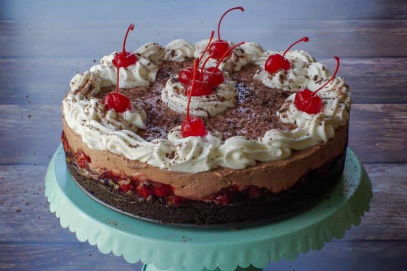No Bake Black Forest Cheesecake on a turquoise cake stand.