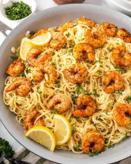 Lemon and garlic shrimp on a bed of gluten free spaghetti in a large skillet.