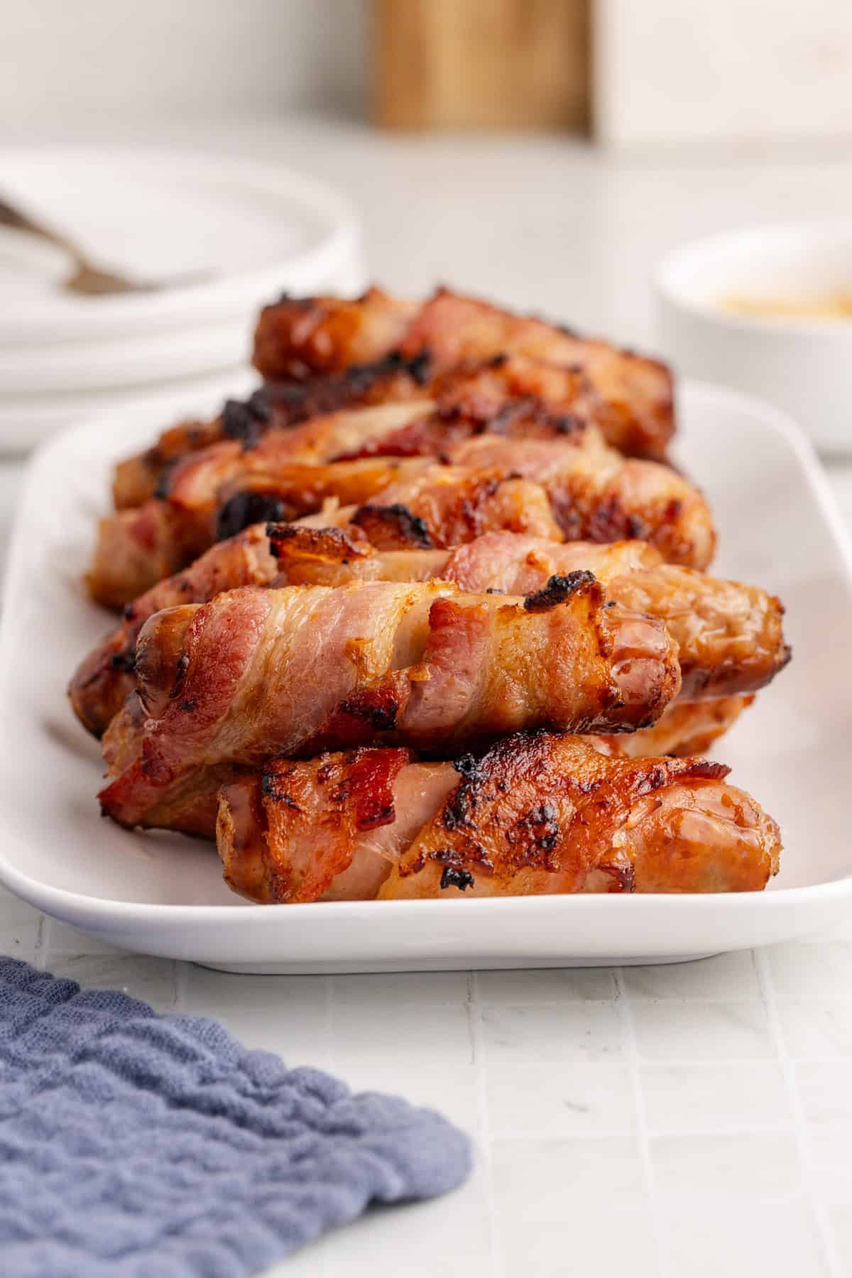 Bacon Wrapped Sausage in Air Fryer on a Serving Platter.