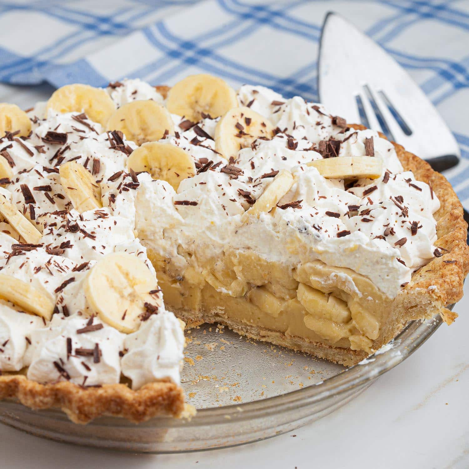 Banana cream pie with a slice missing.