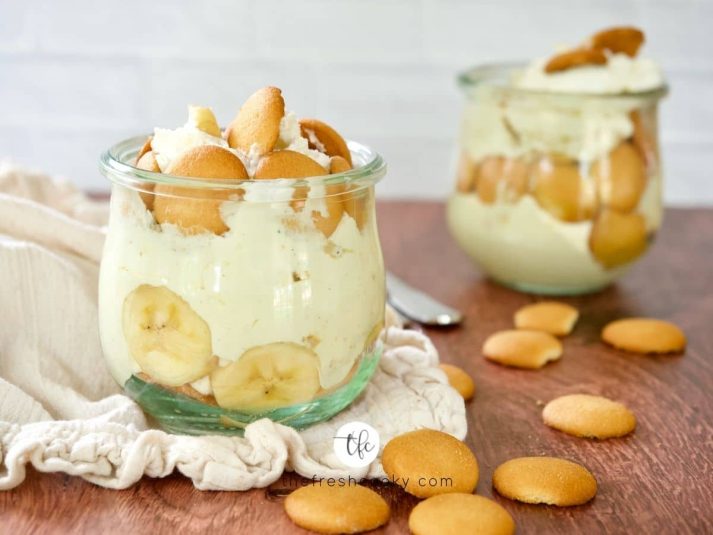 A small jar filled with Magnolia Banana Pudding with another behind with two spoons.