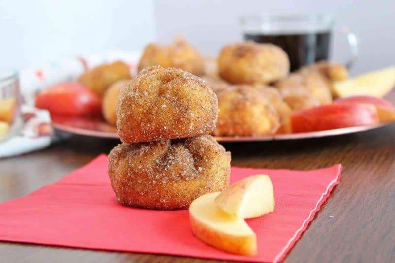 Two air fryer apple pie bites stacked on top of each other on a red napkin.