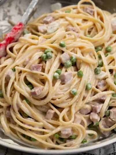 Linguine pasta with ham and green peas in a garlic parmesan sauce.