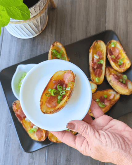 Loaded Potato Skins - on a plate by a plant.