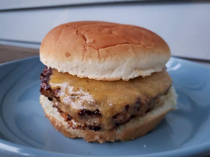 Image shows Asian inspired turkey burger on a blue plate.