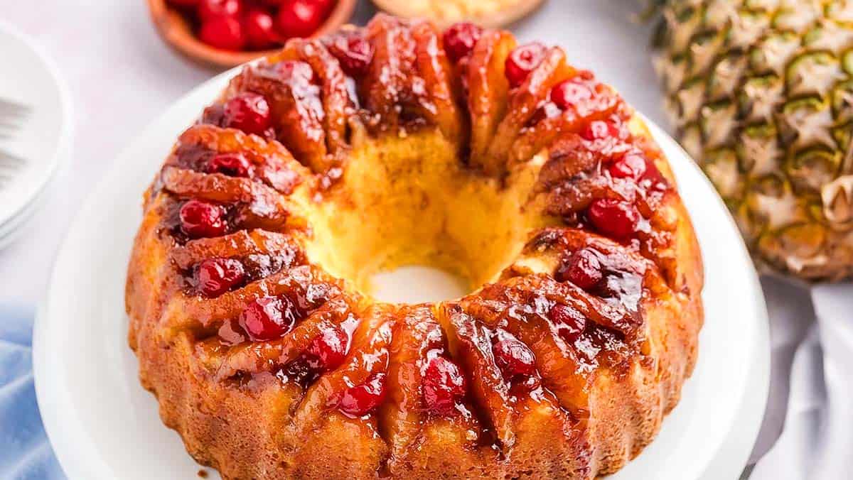 A plate with seasoned grilled chicken, farro, and diced vegetables including tomatoes, cucumbers, and onions, with a fork on the side.