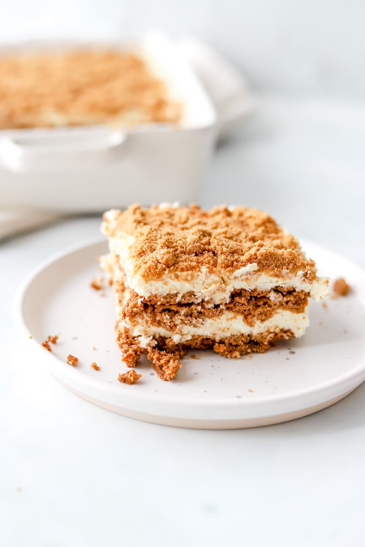 A slice of speculoos tiramisu on a white plate.