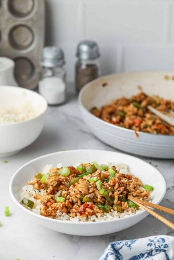 Ground turkey teriyaki being served over rice in a bowl.