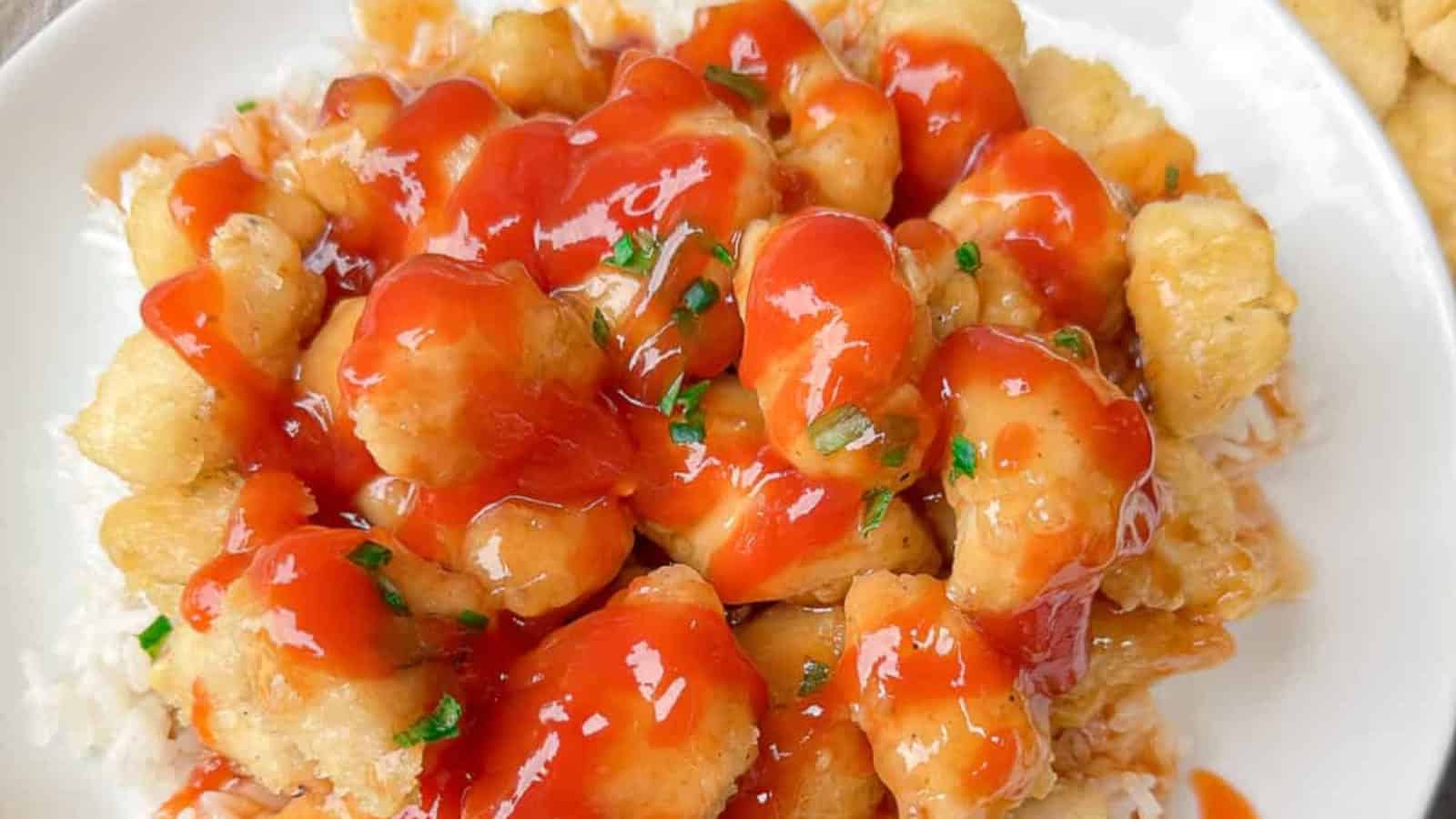 A glass mug filled with pear tea juice and a red straw, surrounded by whole pears, lime slices, and ginger on a wooden surface.