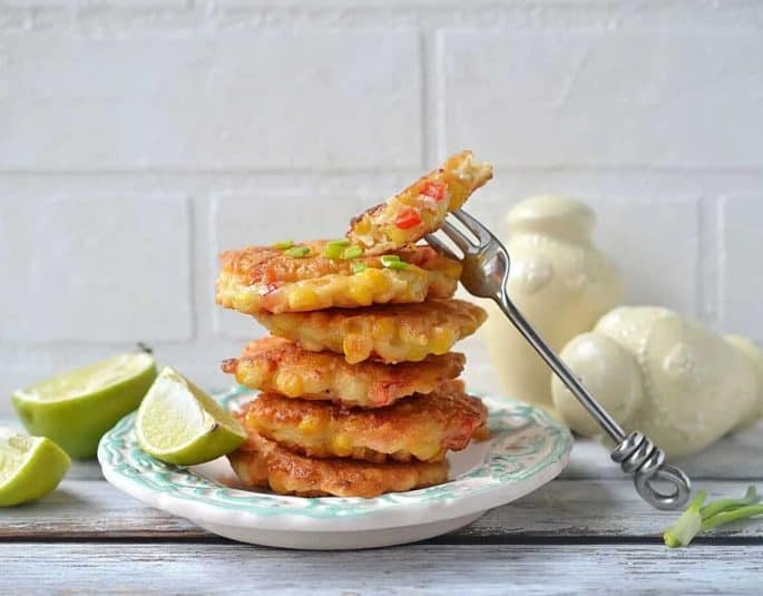 Stack of Mexican corn cakes on a white plate with a fork.