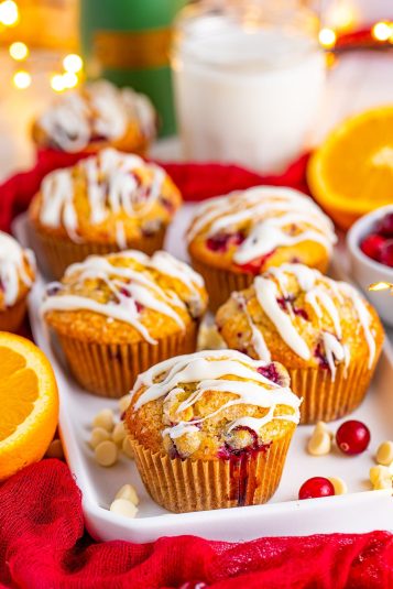 Orange cranberry muffins on a white serving platter.