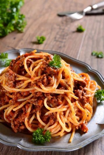 A plate of spaghetti garnished with parsley.