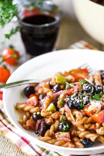 One pot pasta puttanesca in a white bowl.