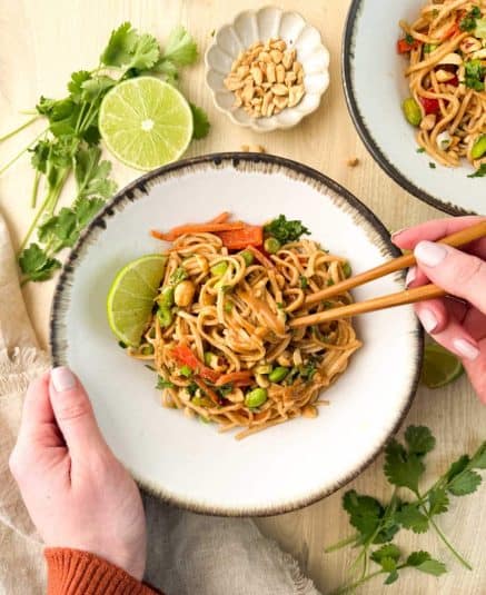 Noodles coated in peanut sauce garnished with scallions.
