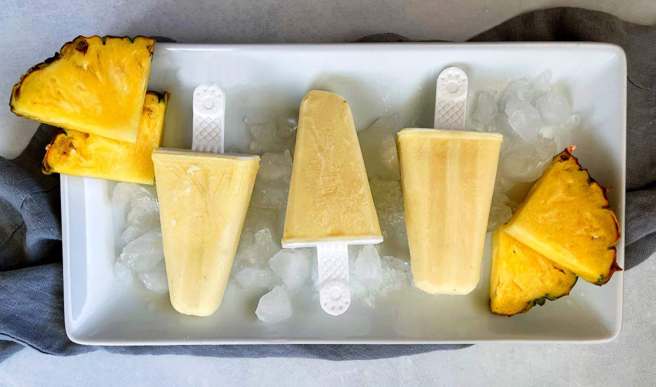 Pineapple popsicles on a tray of ice.