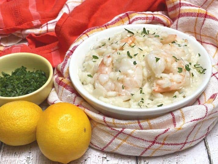A finished Risotto with Prawns amid ingredients.