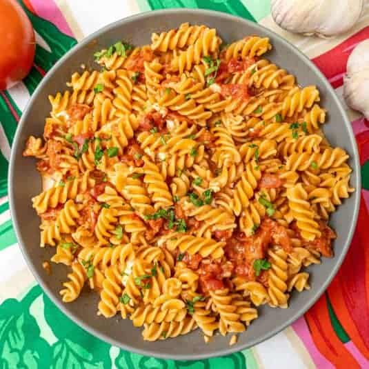A large bowl full of tomato chickpea pasta spirals.