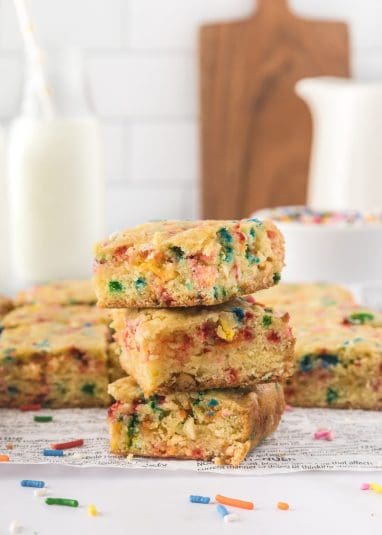 Stacked funfetti blondies on newspaper.