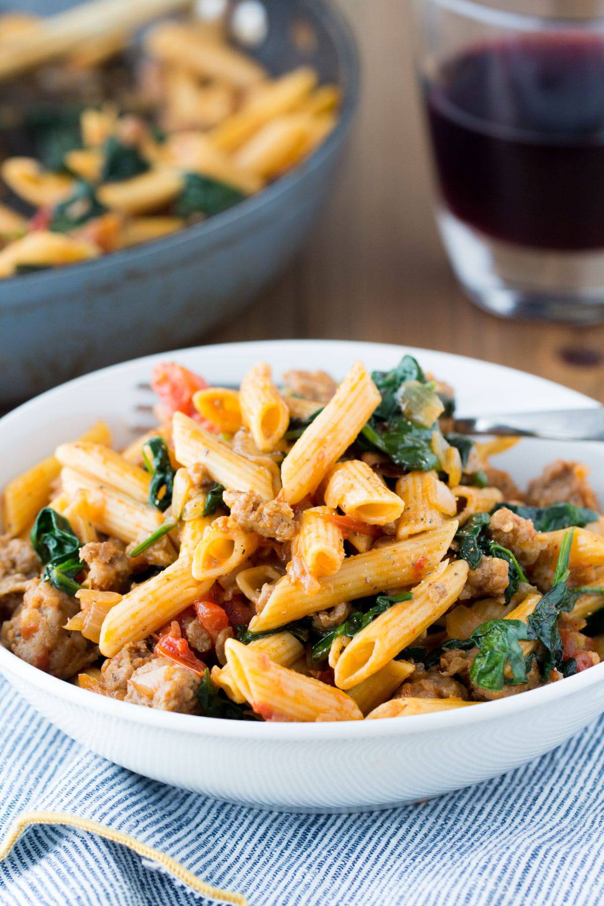 Five Ingredient Pasta with Sausage and Spinach in a white bowl.