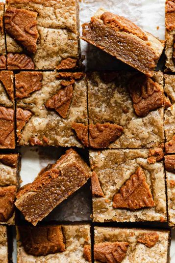 Overhead shot of cut biscoff blondies. Two lay on their edges to expose the fudgy centers.