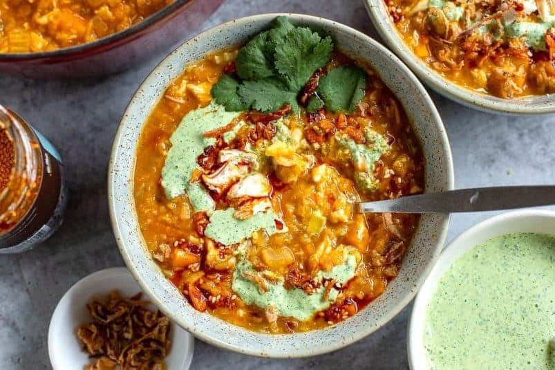 Chicken Lentil Soup in a bowl with cilantro yogurt sauce on top.