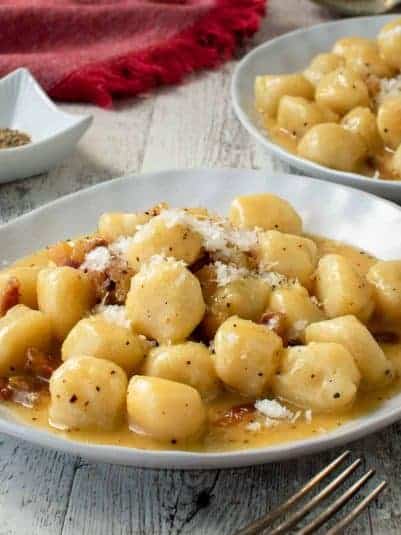 Gnocchi carbonara on a white plate.