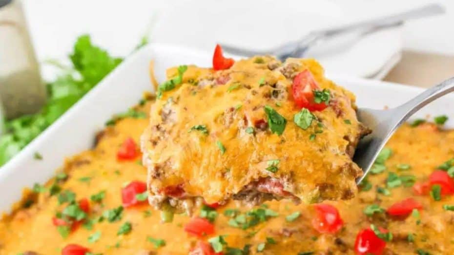 Slice of pecan pie on a white plate with a fork, placed on a burlap surface. The pie has a pastry crust, creamy filling, and is topped with chopped pecans.