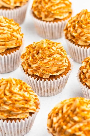 Biscoff cupcakes on a white table top.