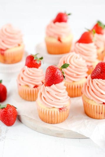 Cupcakes with frosting and fresh strawberry on top.