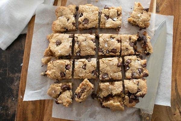 Chocolate pecan granola in a bowl next to a glass of milk.