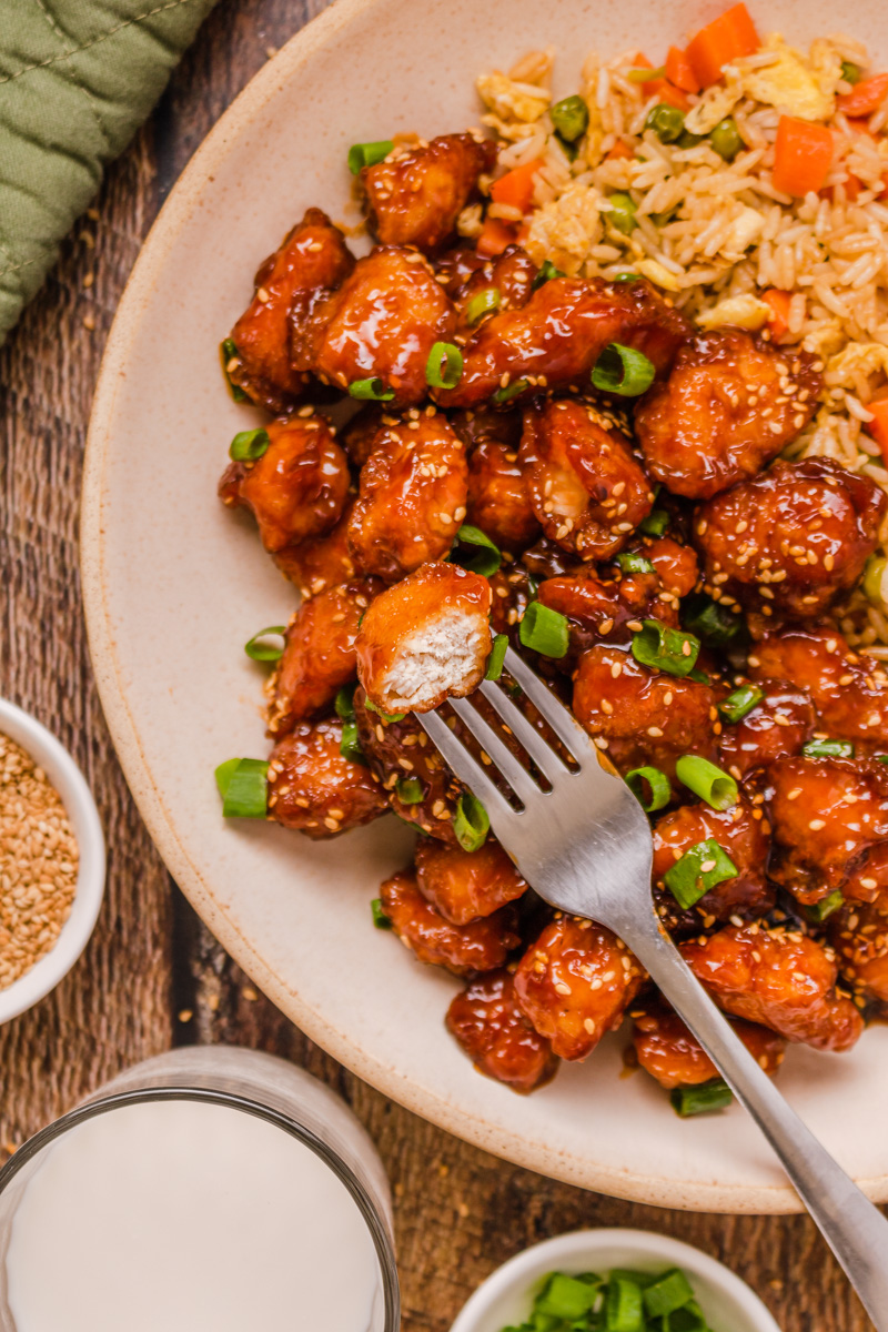 A plate of honey sesame chicken with fried rice.