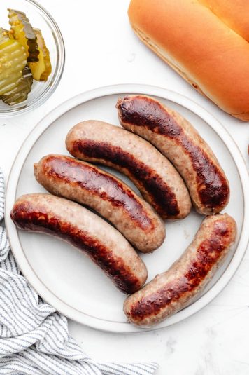 A white plate with 5 Instant Pot brats on it.