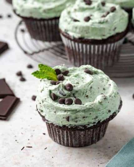 A batch of mint chocolate cupcakes sitting on a wire cooling rack.