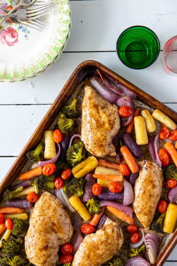 Sheet pan with broccoli, tomatoes, red onions and glazed chicken breasts.