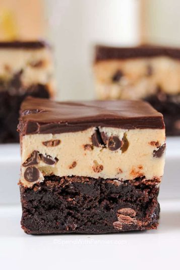 Delicious chocolate peanut butter brownies with layers of cookie dough and creamy chocolate topping.
