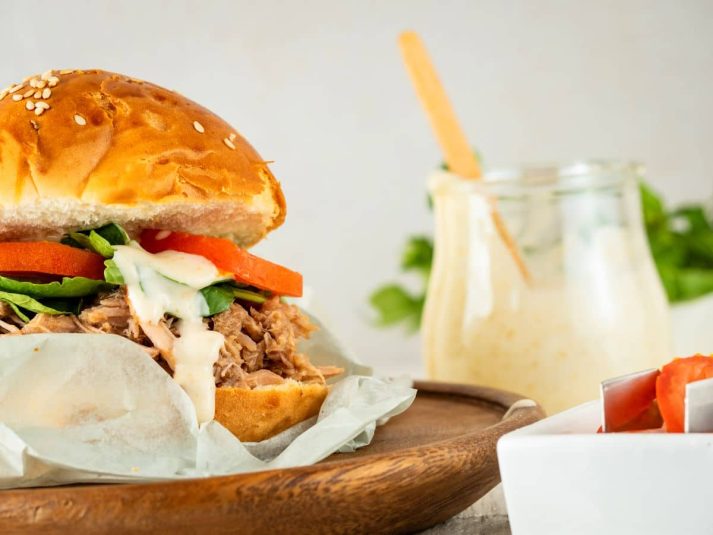 Pulled pork burger on wooden plate.