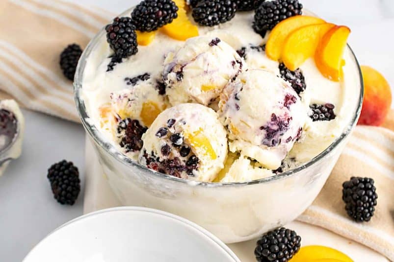 Overhead shot of peach pandowdy with fresh peaches.