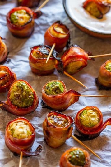 Brussels sprouts wrapped in bacon and served with dip.