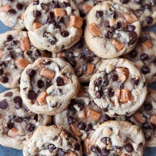 Caramel chocolate chip cookies piled on top of each other.