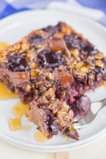 Oatmeal slice on a white plate with a bite on a silver fork.