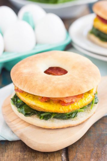 Spinach, Bacon and Feta Breakfast Sandwich on a wooden board.