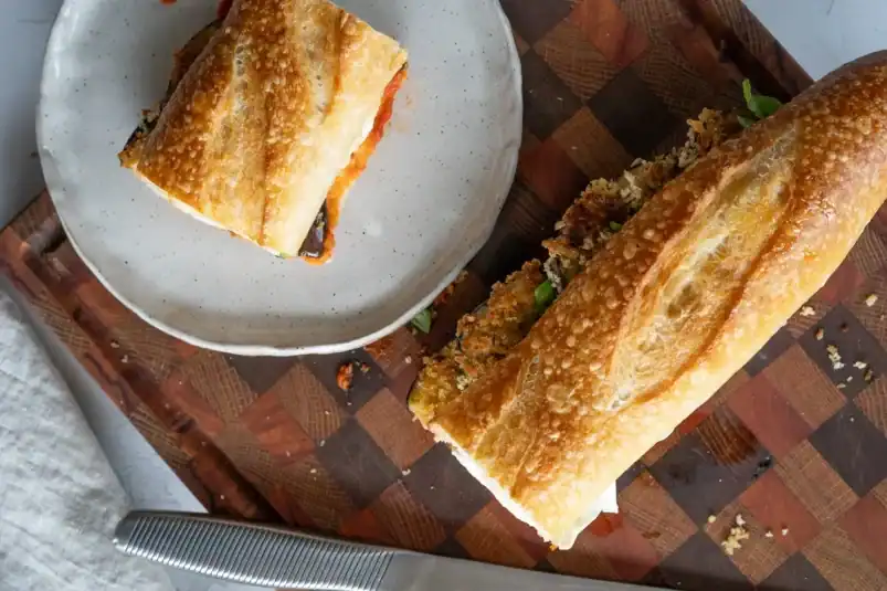 A slice of an eggplant parmesan sandwich on a plate.