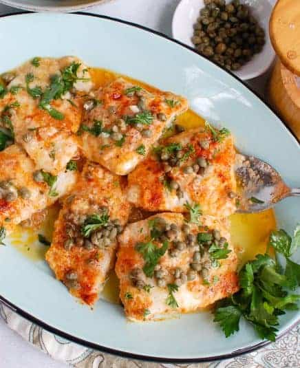 Baked Cod with Lemon on teal platter.