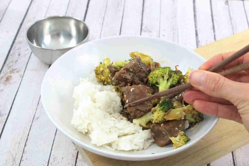 Wrap with steak fajitas, avocados and lime in it and limes and more ingredients around the wrap.